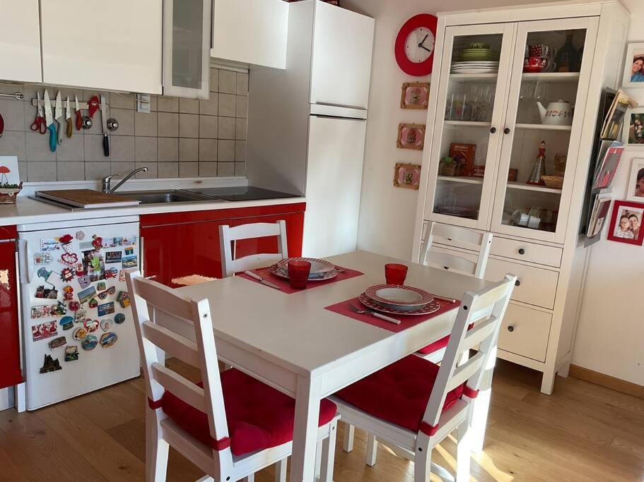 een keuken met een tafel met stoelen en een koelkast bij White Love Versilia in Viareggio