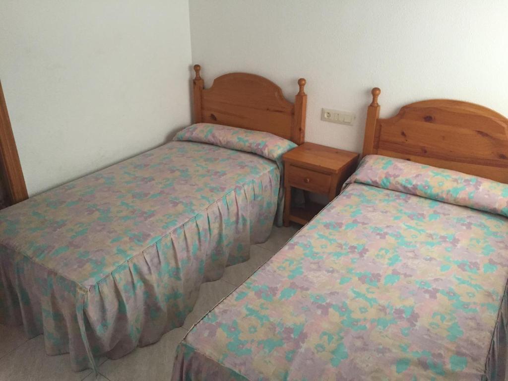 two beds in a small room with at Apartamentos Vicent in Peñíscola