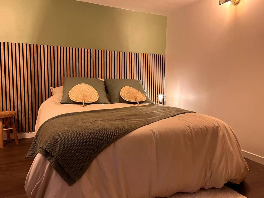a bedroom with a large bed with two lamps on it at La Cosy Green Suite in Colombelles
