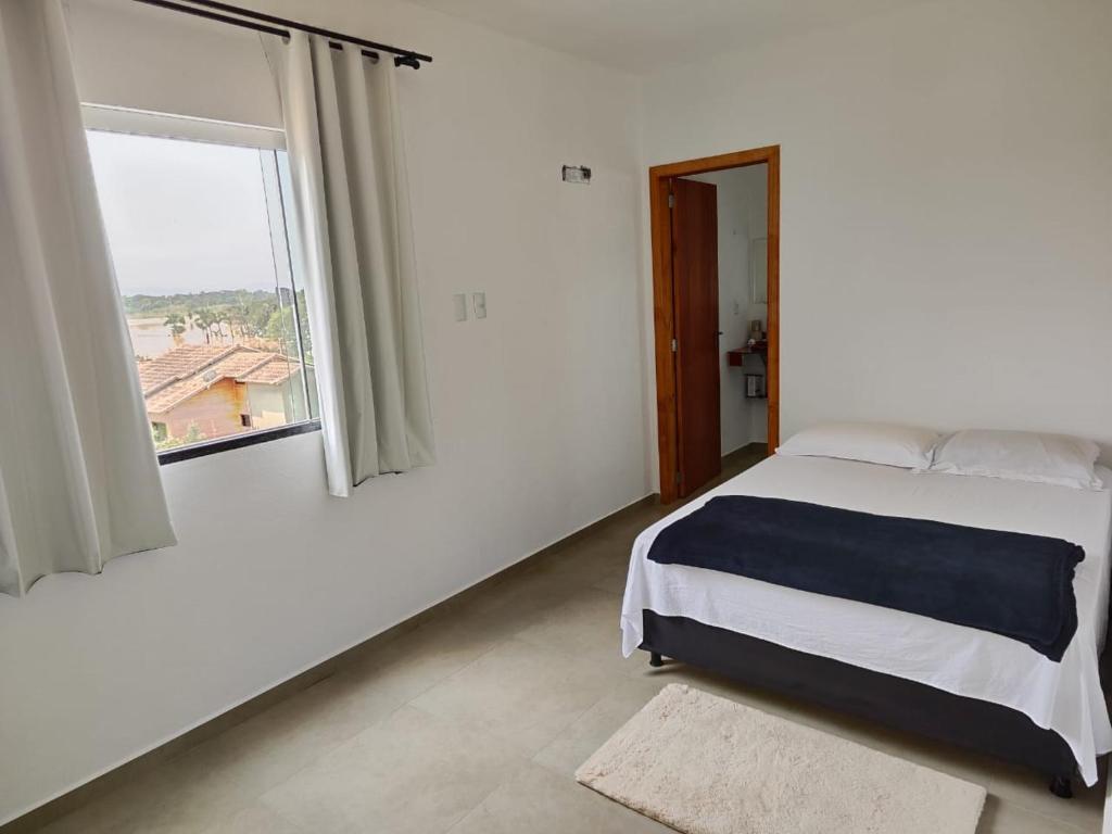 a bedroom with a bed and a large window at Apartamento de 1 quarto próximo a 101 in Itajaí