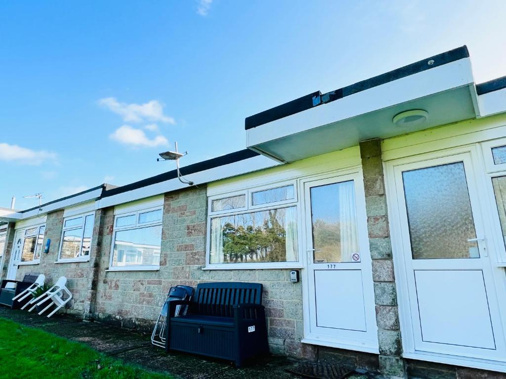 uma casa de tijolos com portas e janelas brancas em 2 Bedroom Chalet SB177 Sandown Isle of Wight em Brading