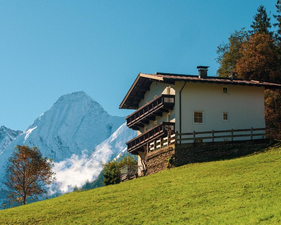 a house on a hill with a mountain in the background at Landhaus Maria in Hippach