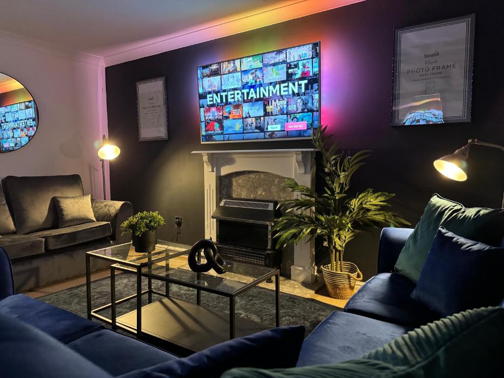 a living room with a fireplace and a tv at Rooms Near Me - Central Birmingham Free Parking in Birmingham