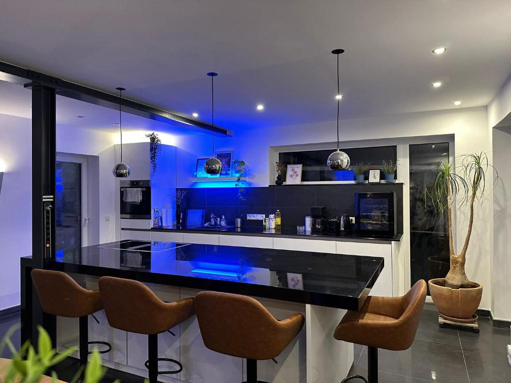 a kitchen with a black counter and some chairs at Business Apartment/Loft nähe Bonn in Königswinter