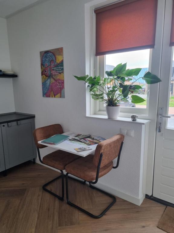 a table and a chair in a kitchen with a window at Haardstee in Borger