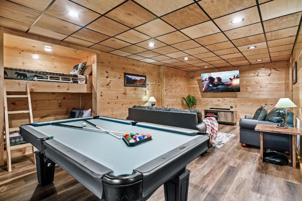 a pool table in a room with wooden walls at cul-de-sac Cabin on Parkway, 2King Beds & Bunk Beds, Hot Tub, Arcade Games in Pigeon Forge