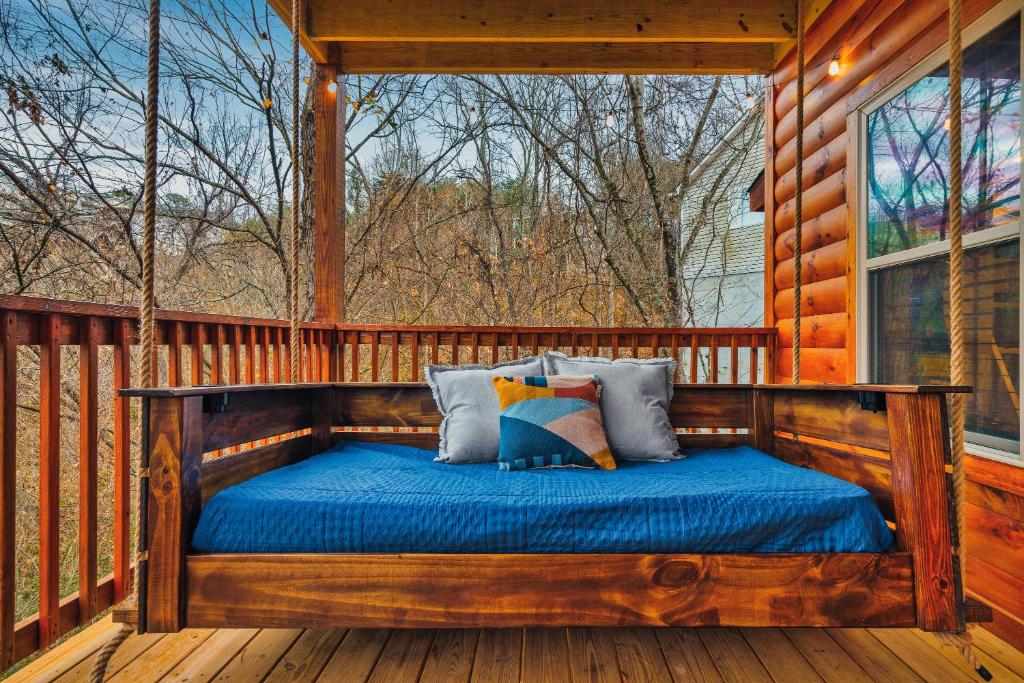 a bed on the porch of a log cabin at cul-de-sac Log Cabin, Hot-Tub, Arcade Games, In-Built Bunk beds, Level2 EV On site in Pigeon Forge