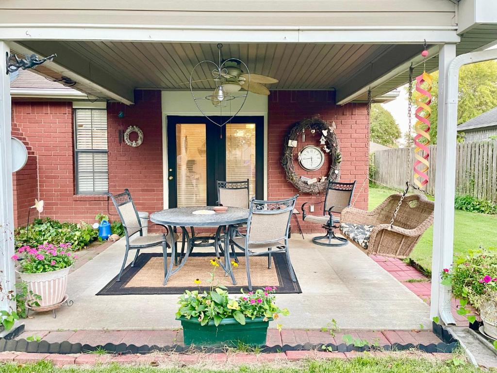 a patio with a table and chairs in front of a house at Cozy house centrally located close to everything in NWA in Springdale