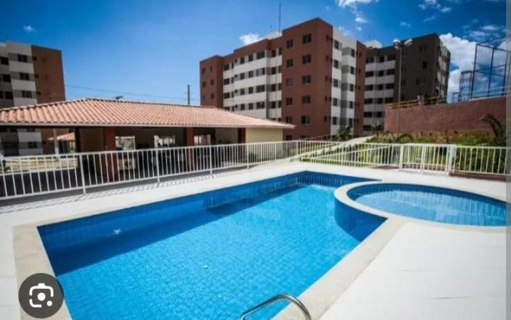 a large swimming pool in front of some buildings at Apartamento confortável e sofisticado em Aracaju in Aracaju
