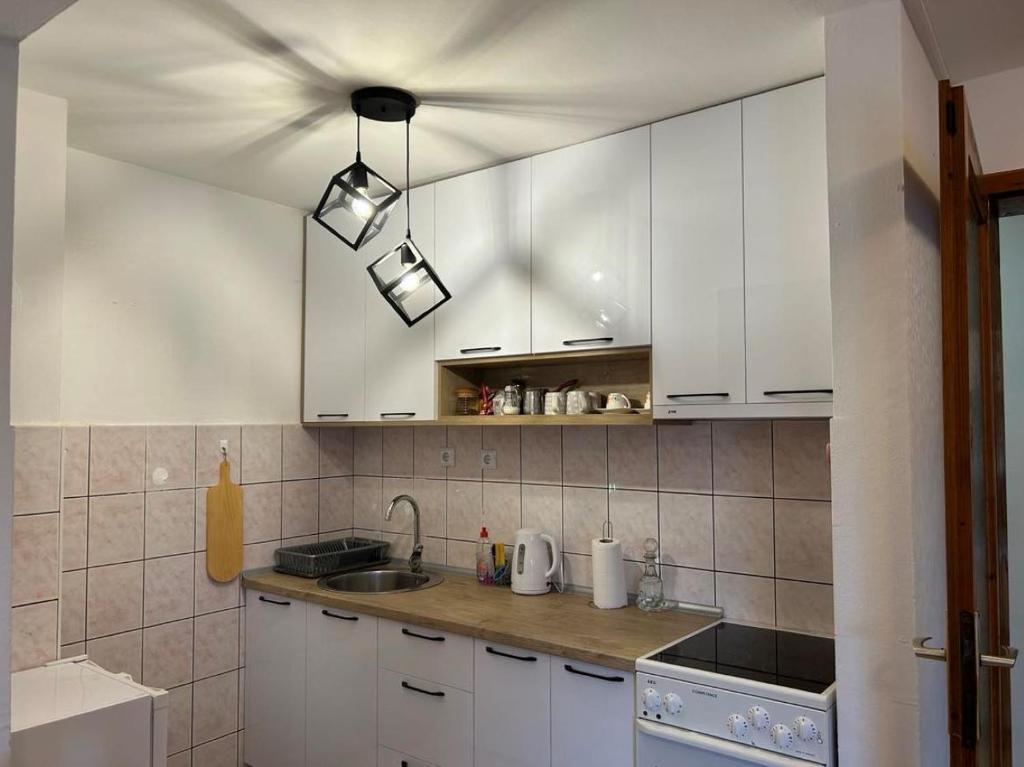 eine Küche mit weißen Schränken und einem Waschbecken in der Unterkunft Paradiso 5 in Bratunac