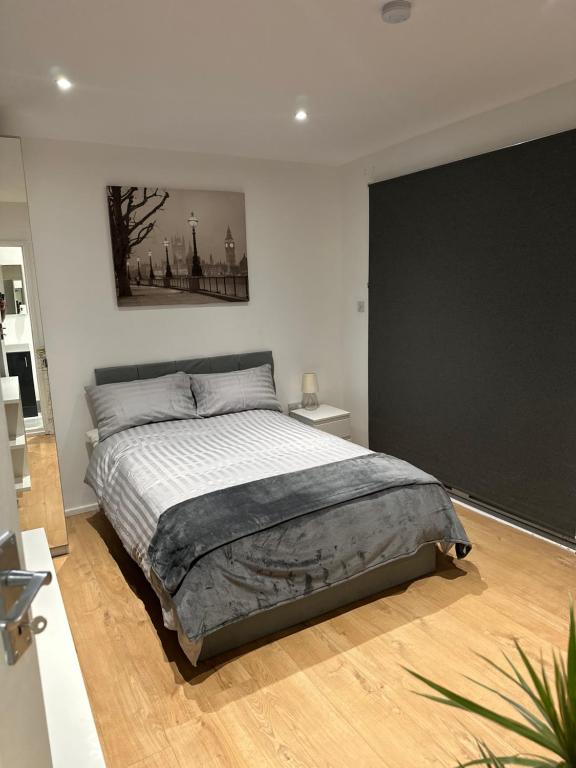 ロンドンにあるSelf-contained en-suite room very close to Wembley stadiumの白い部屋に大型ベッド1台が備わるベッドルーム1室が備わります。