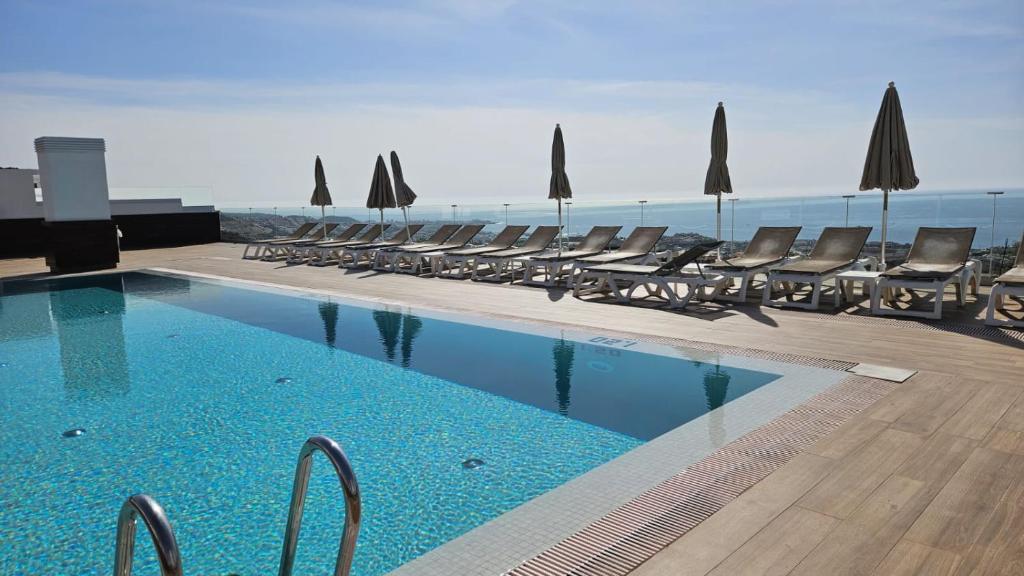 - une piscine avec des chaises et une vue sur l'océan dans l'établissement El Tesoro, beautiful, two bedrooms tenerife sur, à Adeje