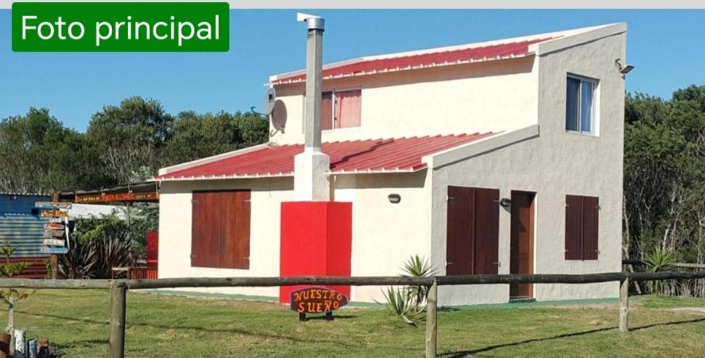 una pequeña casa con un rojo y blanco en Casa Nuestro Sueño en Punta del Diablo