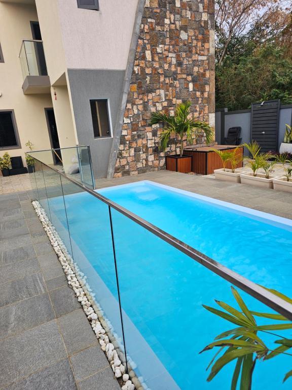 a swimming pool with a glass railing next to a building at AP Villa Tourist Residence 16467 in Flic-en-Flac