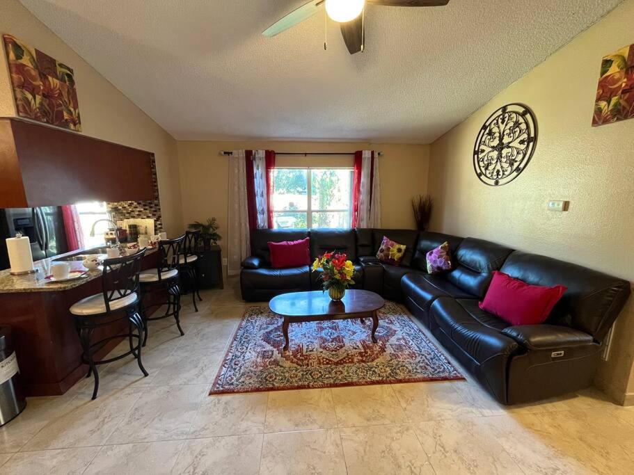 een woonkamer met een zwarte leren bank en een tafel bij Beautiful Modern 3 BR House - Downtown Orlando in Orlando