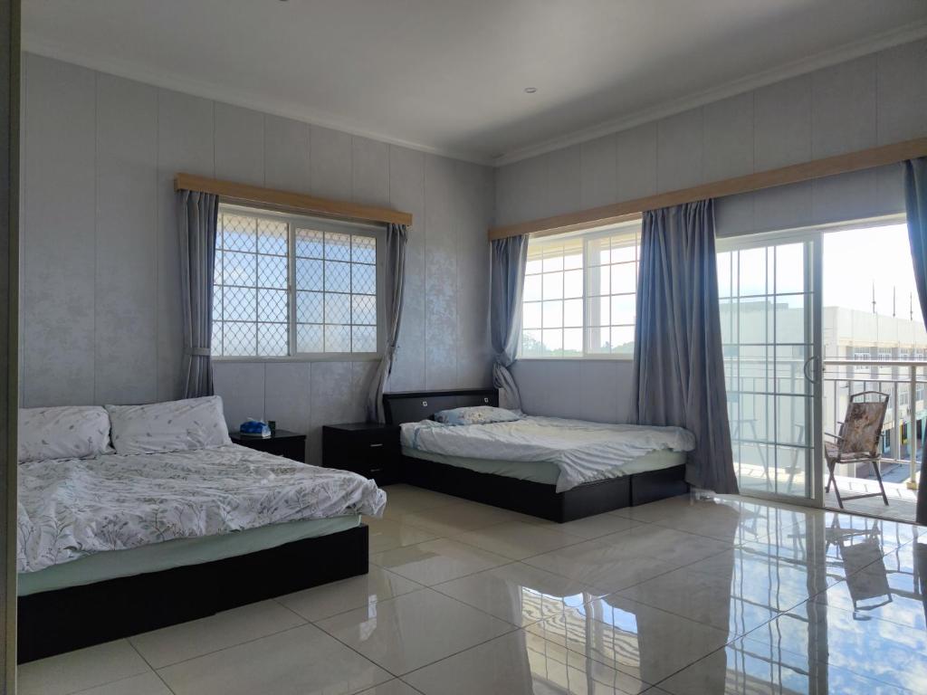 a bedroom with two beds and a balcony at Dupincia Lodge in Nuku‘alofa