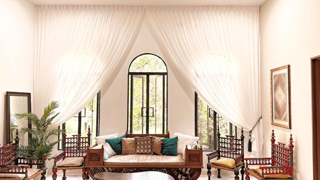 a living room with a couch and some windows at The Manzil Janda Baik in Bentong