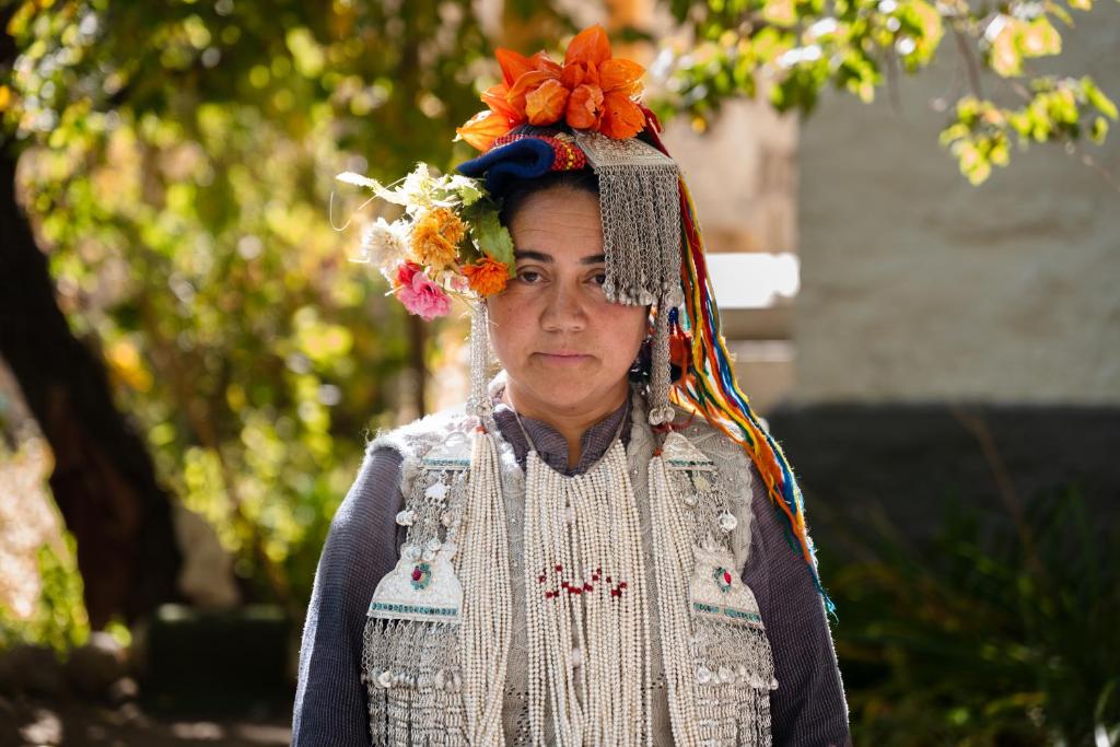 a woman wearing a head dress and a flower headdress at Garkone Homestay in Dah