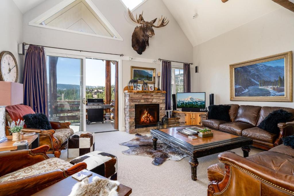 a living room with leather furniture and a fireplace at Saddle Ridge V2 by Moonlight Basin Lodging in Big Sky