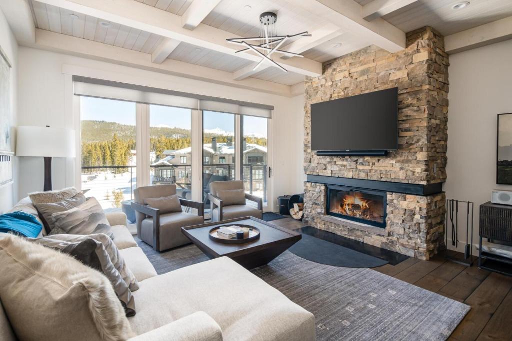 a living room with a fireplace and a tv at 16 Wildwood by Moonlight Basin Lodging in Big Sky