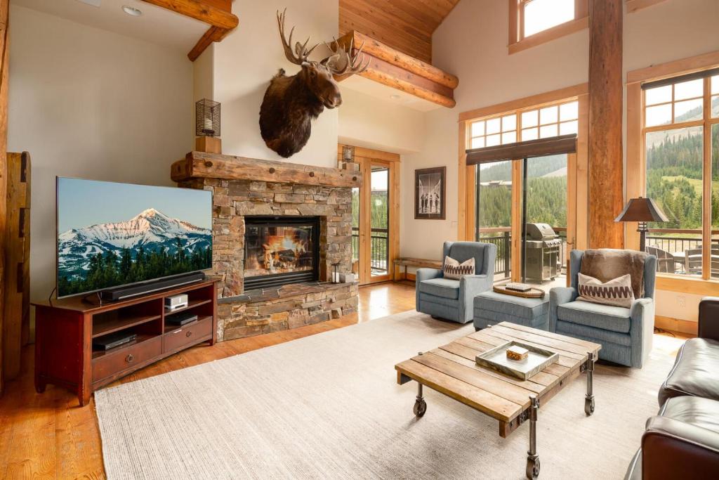 a living room with a fireplace and a tv at Penthouse 3 by Moonlight Basin Lodging in Big Sky