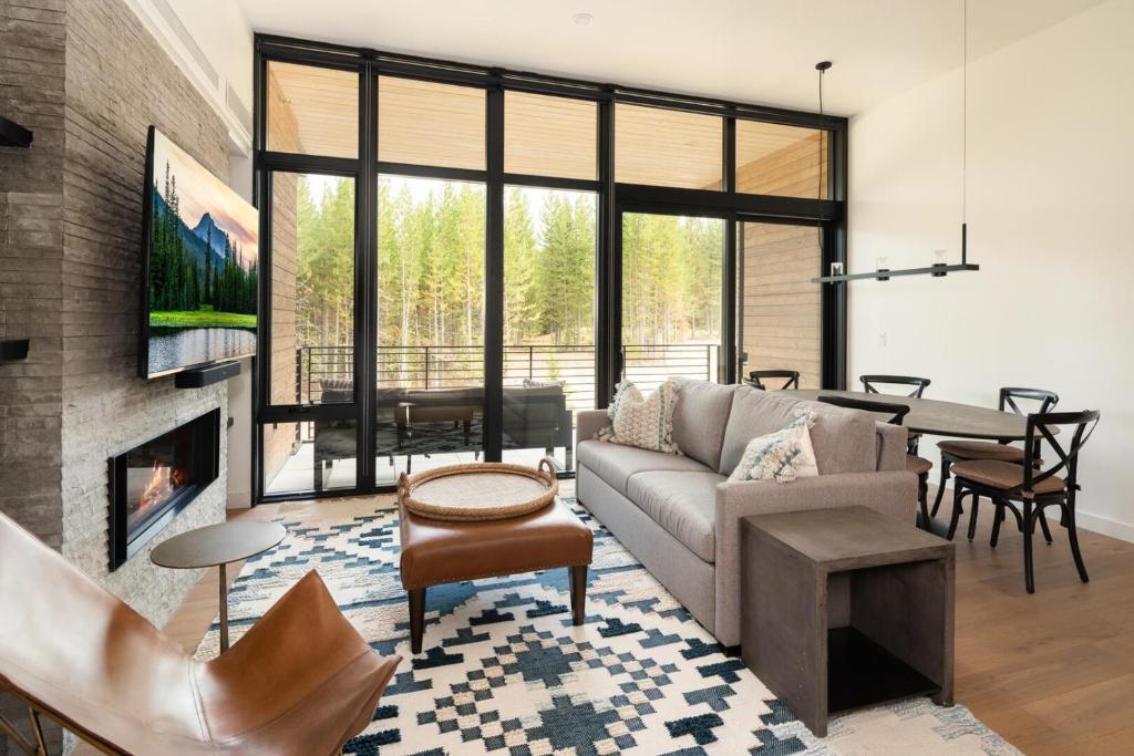 een woonkamer met een bank en een open haard bij 221 LakeLodge by Moonlight Basin Lodging in Big Sky