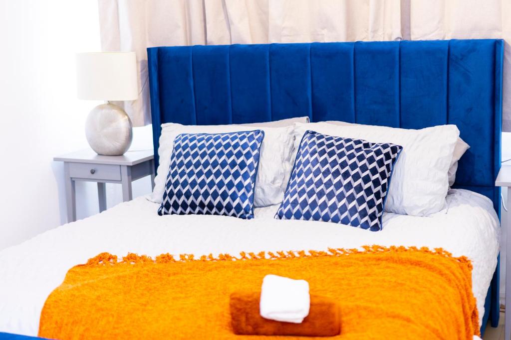 a blue and white bed with blue and white pillows at Elegant 3 bed house in the heart of London in London