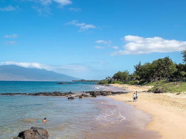 a group of people walking on a beach at Cozy Condo in Kihei at Kamaole Sands Building 3 Unit 202 in Wailea