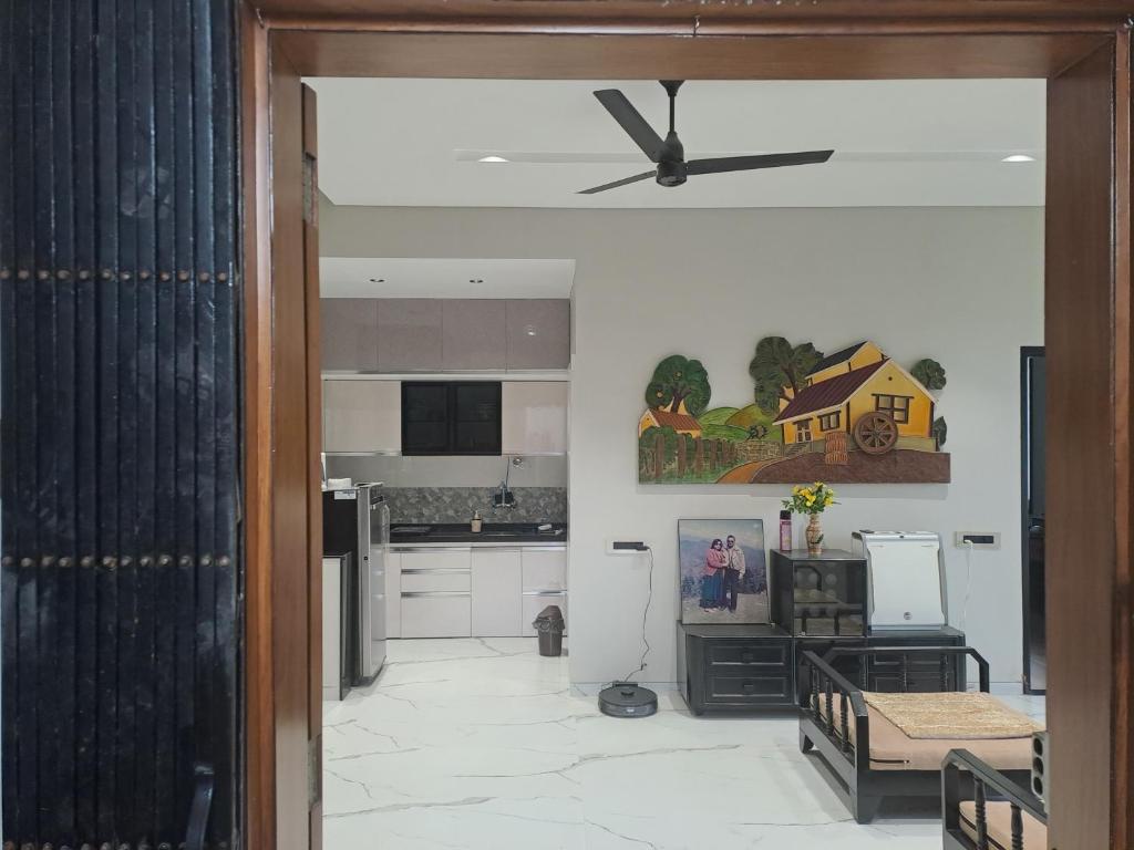 a living room with a ceiling fan and a kitchen at At par with 5 star hotel.. in Pune