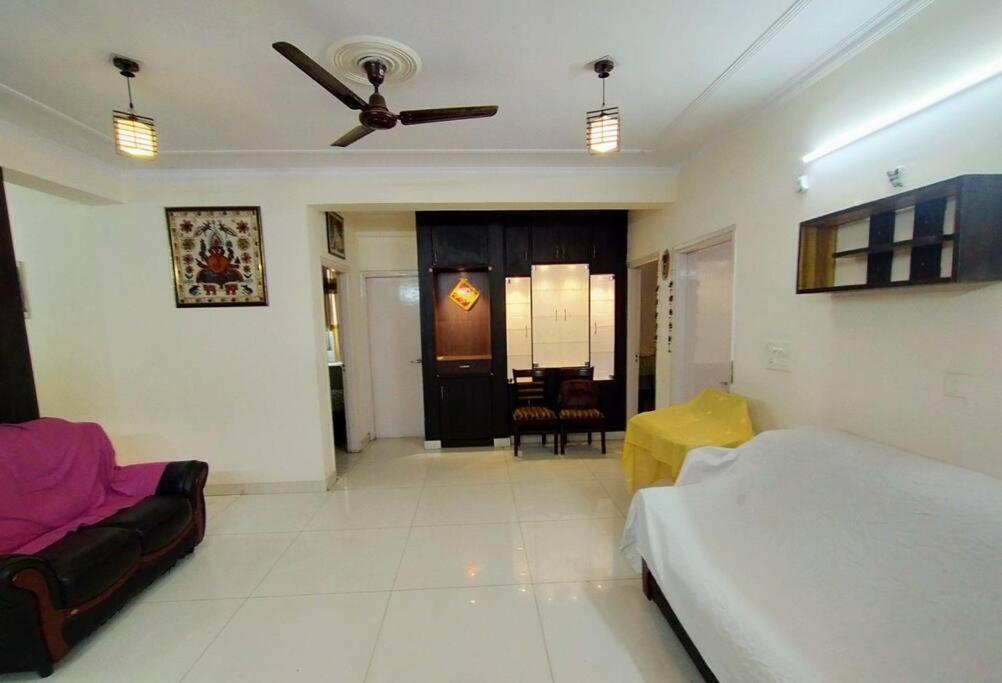 un soggiorno con letto e ventilatore a soffitto di Sharma's Exquisite 2 BHK HomeStay in City of Taj ad Agra