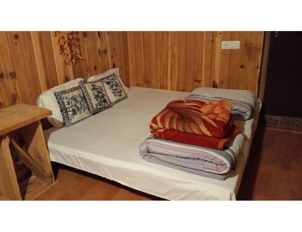 a bed with a blanket on top of it at Hotel Mountain View, Chakrata in Chakrāta