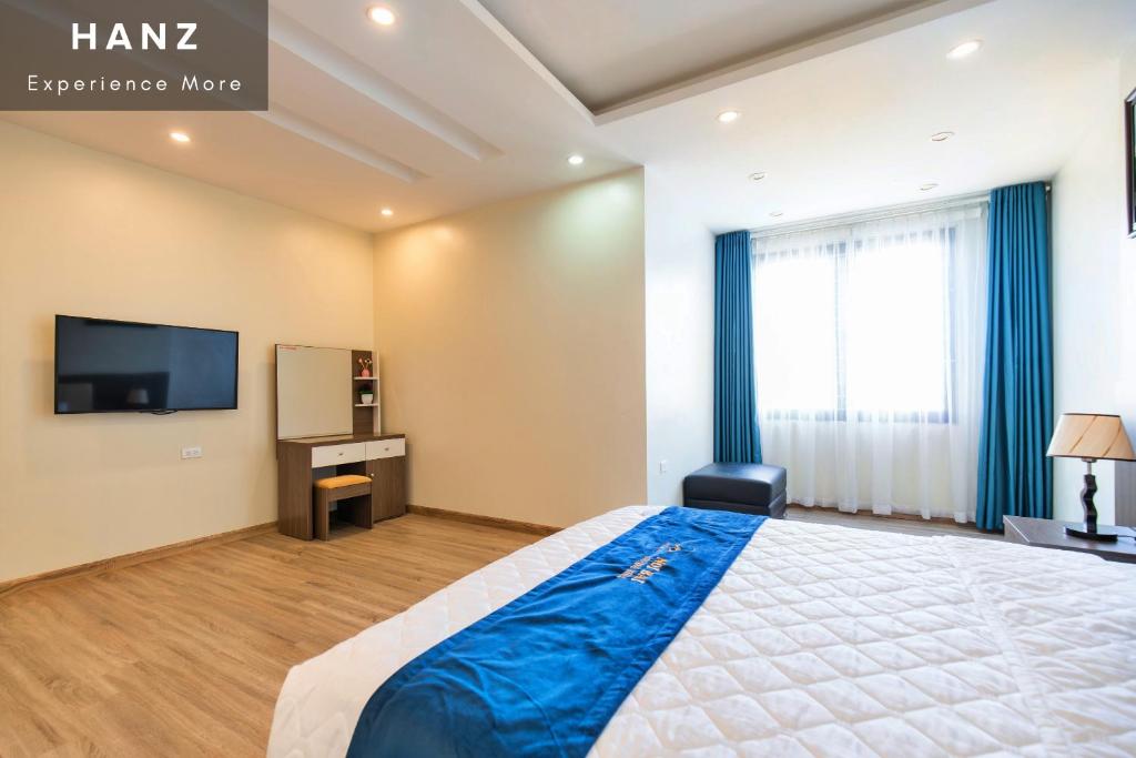 a bedroom with a large bed and a television at HANZ Noi Bai Airport Hotel in Hanoi