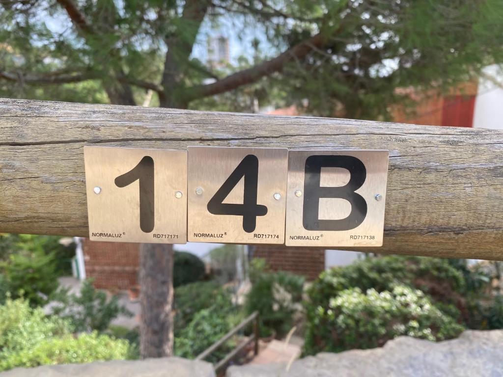 a sign on a wooden fence with numbers on it at Canyelles BBQ Apartment in Lloret de Mar
