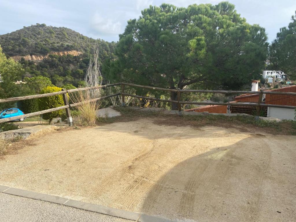 a dirt road next to a fence with trees at Canyelles BBQ Apartment in Lloret de Mar