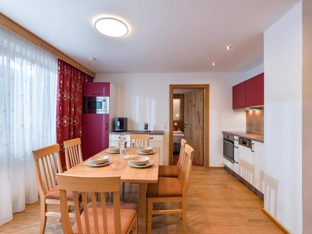 una cucina e una sala da pranzo con tavolo e sedie in legno di Hotel Feichter a Söll