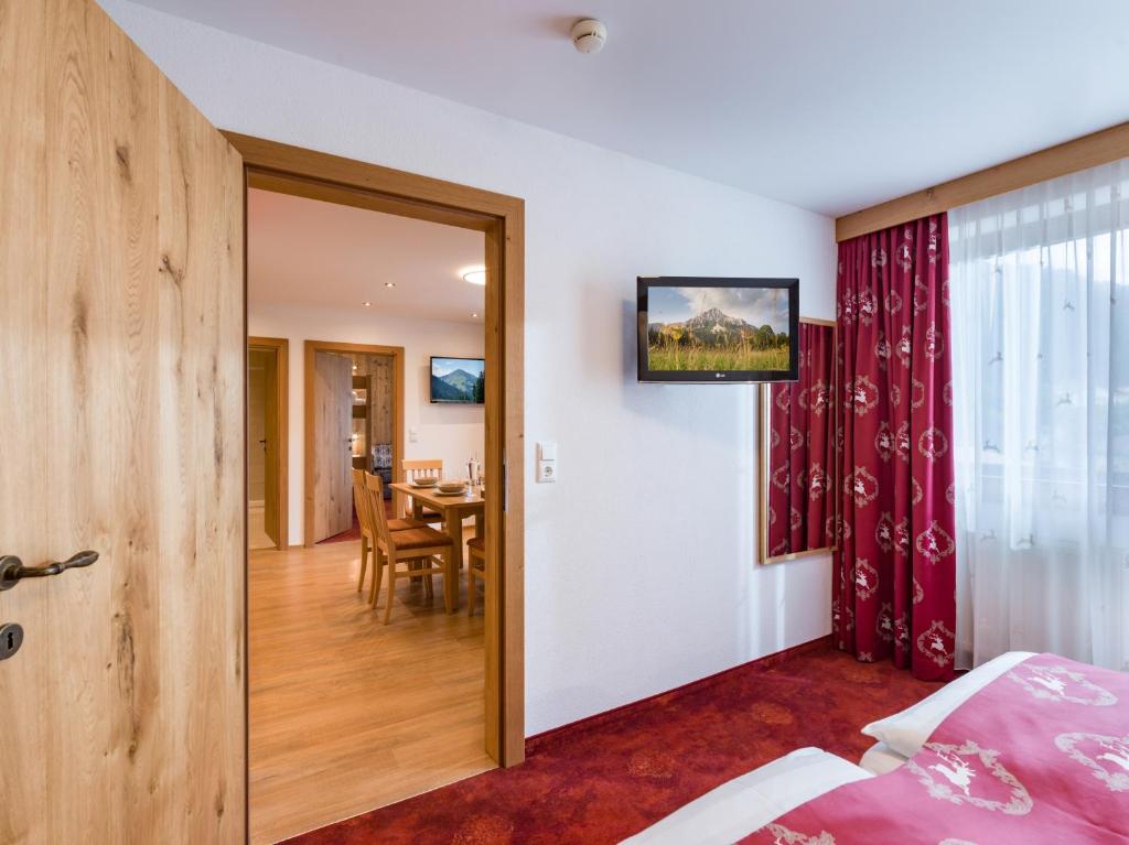una camera da letto con porta che conduce a una sala da pranzo di Hotel Feichter a Söll