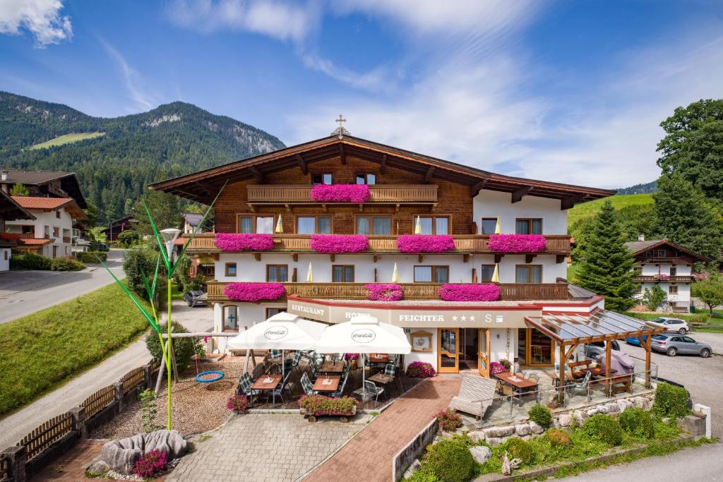 an aerial view of a hotel with tables and umbrellas at Hotel Feichter in Söll