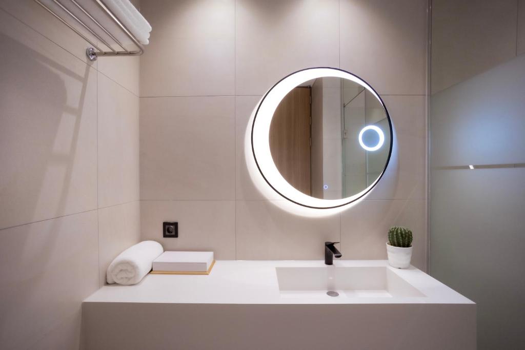 a white bathroom with a sink and a mirror at Luel Hotel in Jeonju