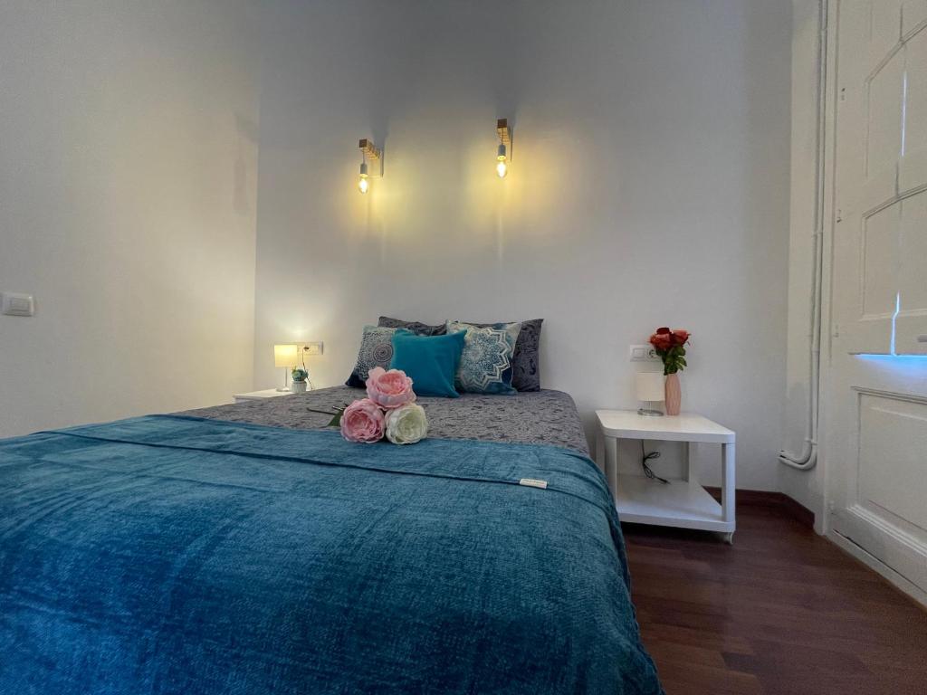 um quarto com uma cama azul com dois ursos de peluche em Rooms in Heart of Gothic em Barcelona