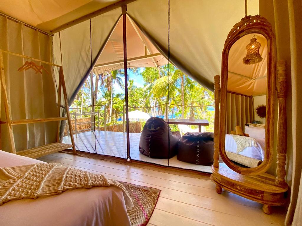 a bedroom with a bed and a mirror and a balcony at Exotic Private Glamping in Nusa Penida