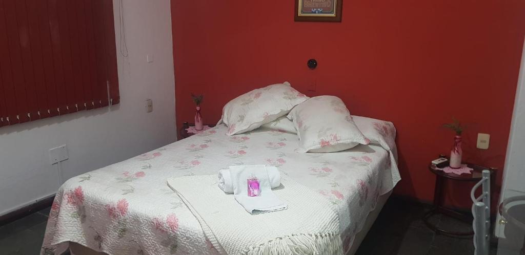 een bed met twee kussens en een roze kaars erop bij Hotel Bella Unión in Bella Unión