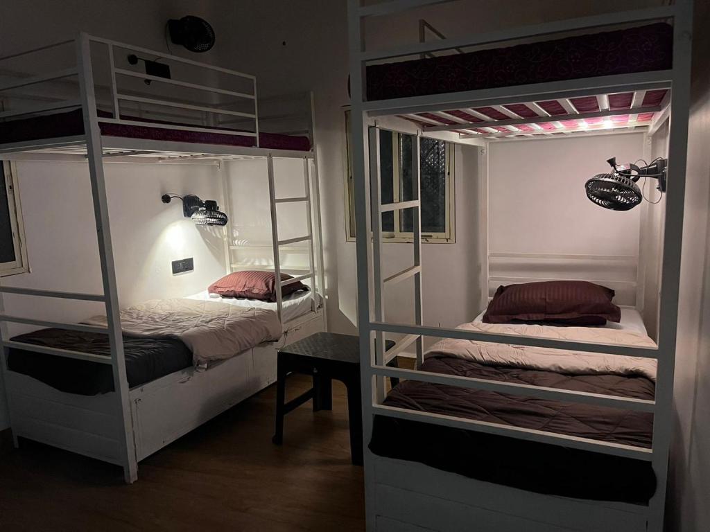 two bunk beds in a room with a table at Seven Tales in Anjuna