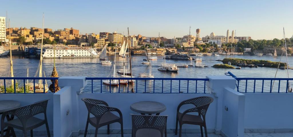 a balcony with chairs and a view of a harbor at La Terrace in Aswan
