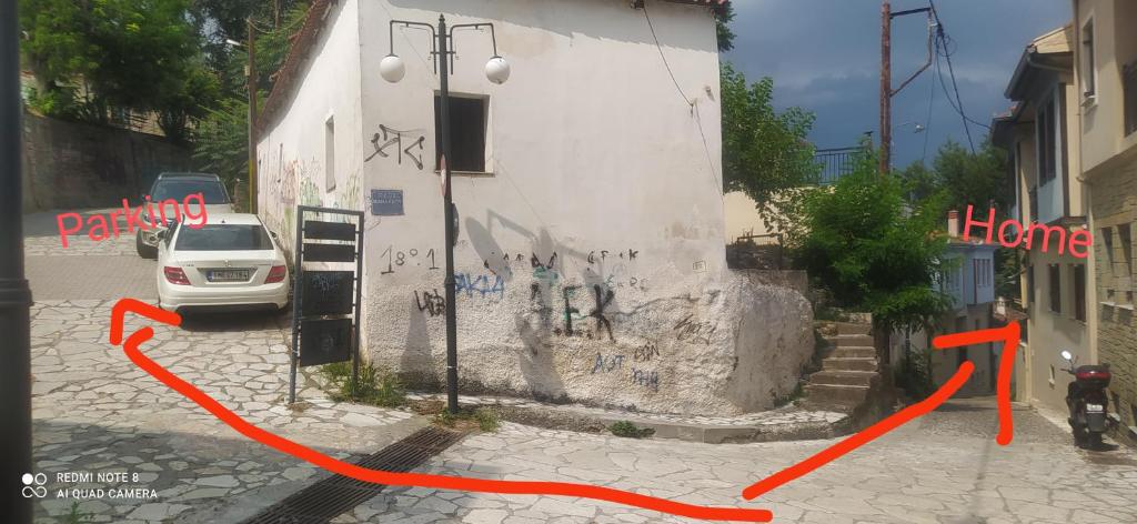 a car parked next to a building with graffiti on it at Varousi.Traditional house in old town of Trikala 1 in Tríkala