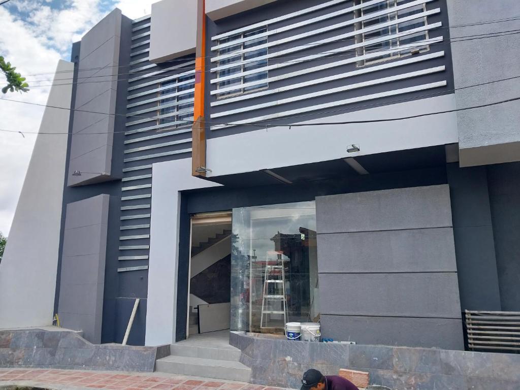 a man is standing outside of a building at Grace Hotel Guaranda 
