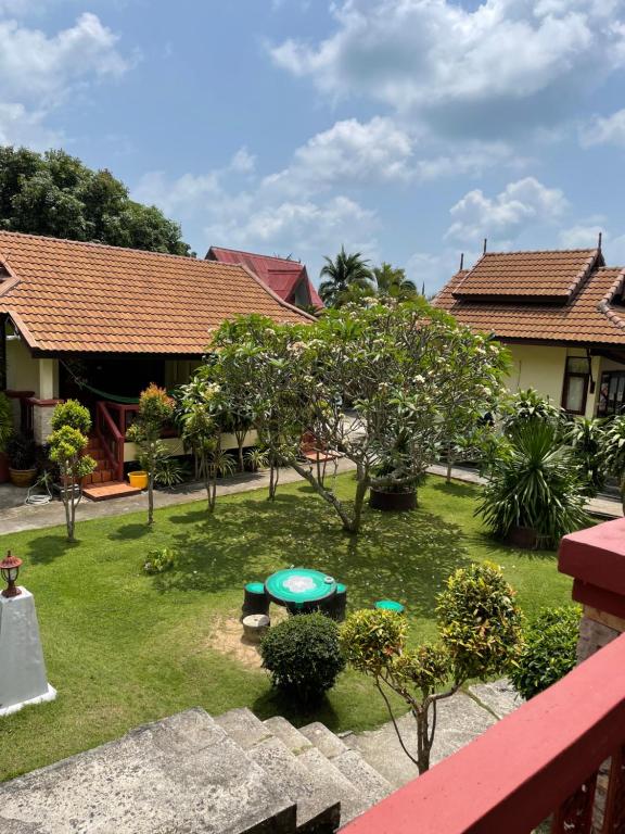 Blick auf einen Garten mit einem Tisch und Bäumen in der Unterkunft Starlight Haadrin Resort in Haad Rin