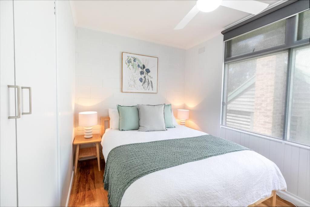 a white bedroom with a bed and a window at Orton Waves- Beach Life Awaits in Ocean Grove