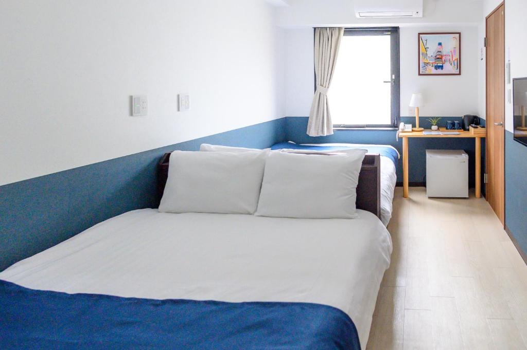 Postel nebo postele na pokoji v ubytování Ueno Woo Hotel