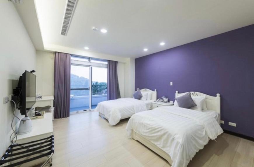 東引鄉的住宿－北澳秘山居 ，一间卧室设有两张床和紫色墙壁