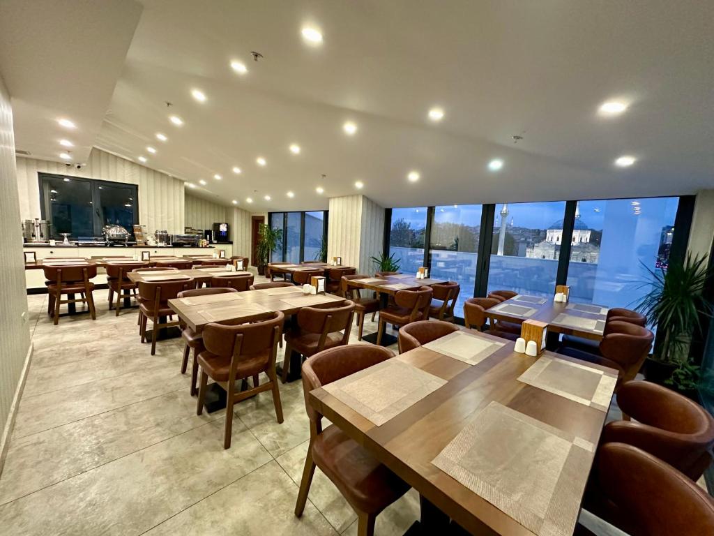 - un restaurant avec des tables, des chaises et de grandes fenêtres dans l'établissement Istanbul Midpoint Hotel, à Istanbul